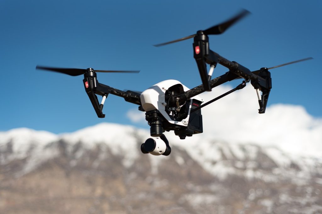 drone insurance | an unmanned aerial system flying over the mountains | telos aerial imaging